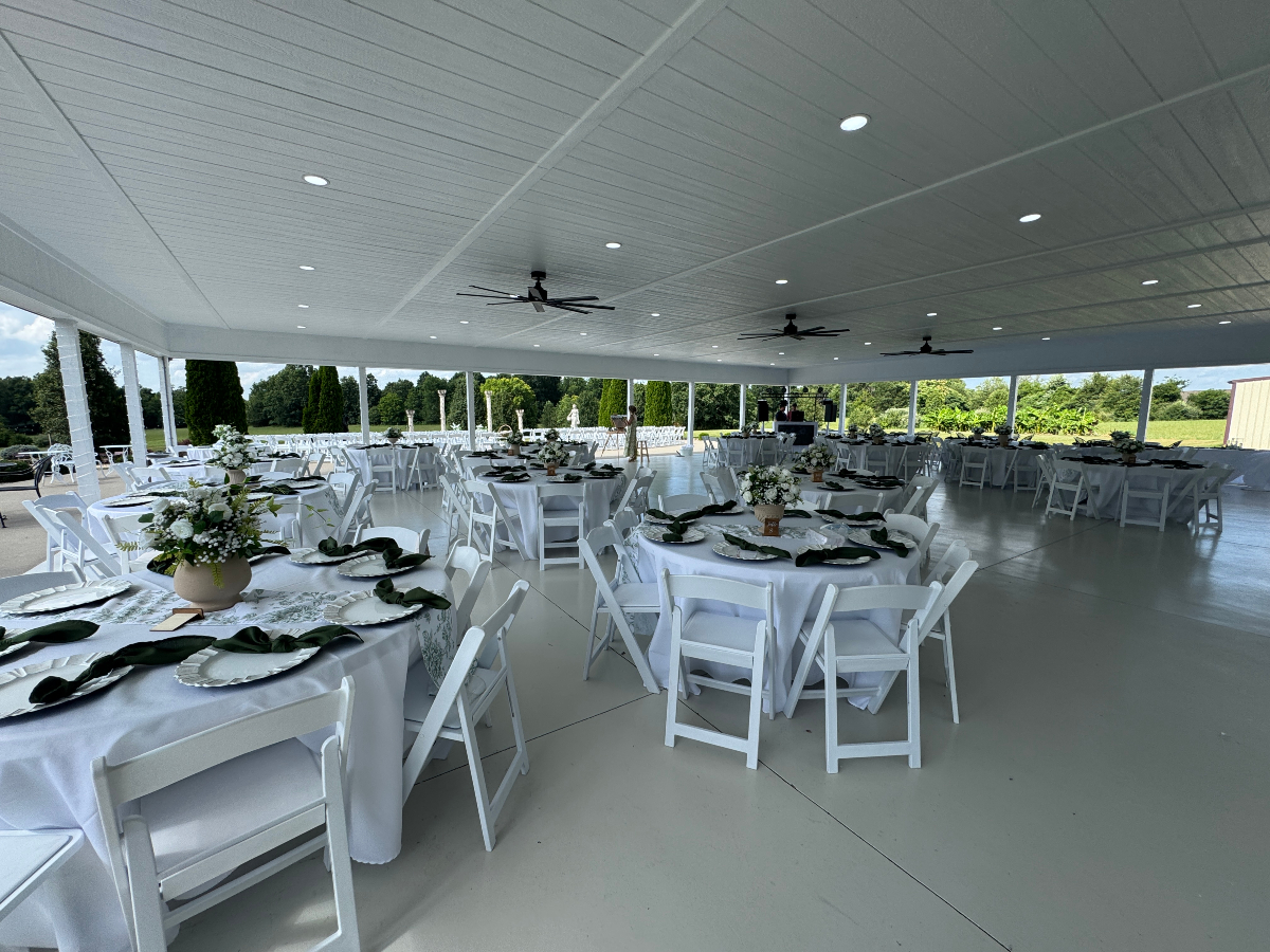 Covered pavilion dining area with elegant table settings and scenic views